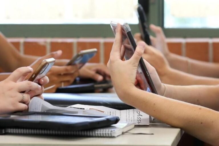 Celulares sendo utilizados por alunos na escola.