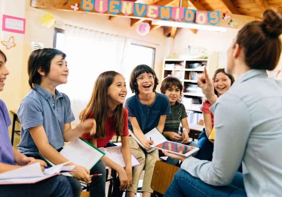 Afetividade e Aprendizagem: Professora e alunos de 10 a 11 anos em clima agradável na sala de aula.