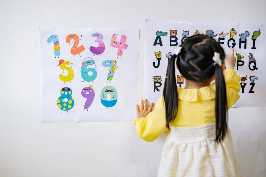 Repedção e desenvolvimento infantil: criança brincando com o afabeto e os numerais.